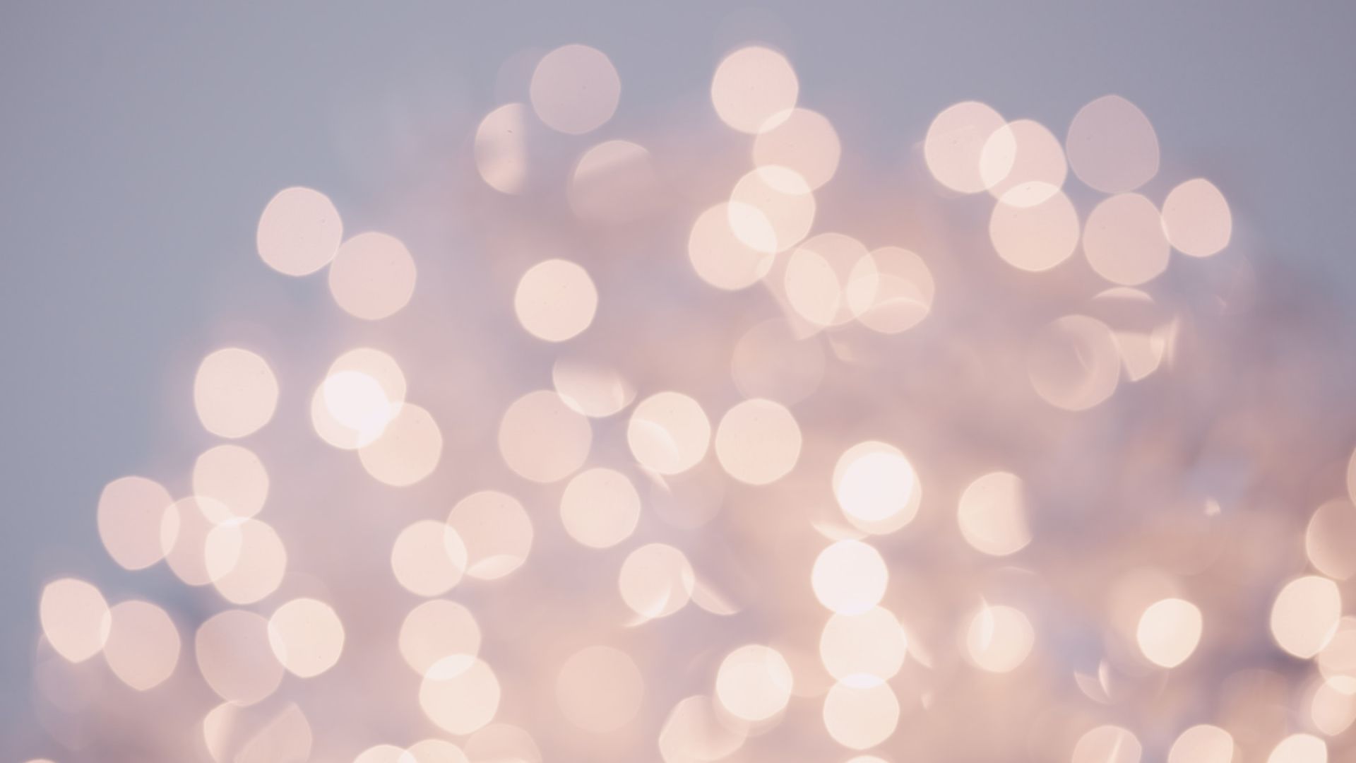 The image shows an abstract scene with numerous blurred, out-of-focus lights creating a soft bokeh effect against a neutral background.